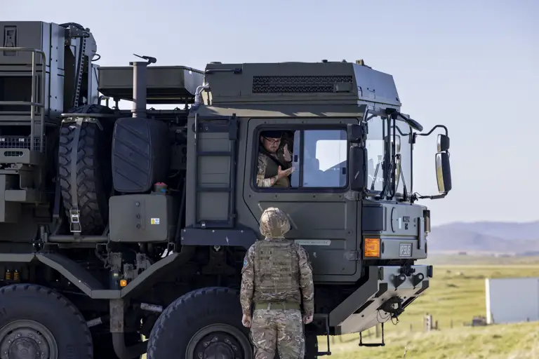 Pictured here is a soldier working on the Land Ceptor missile delivery vehicle with a driver talking to a soldier on the ground out the window of the vehicle. 