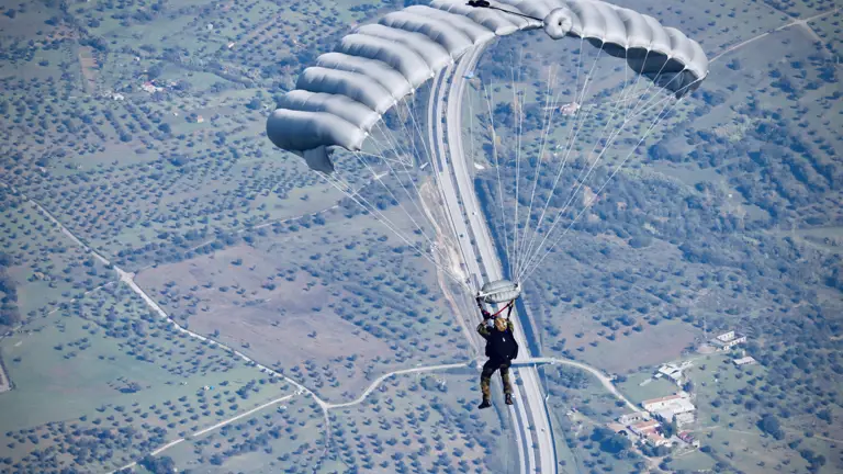 A person descends under a parachute.