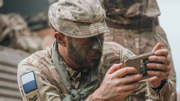 A British Soldier in camouflage uniform is testing his radio communication equipment in a jungle enviroment.