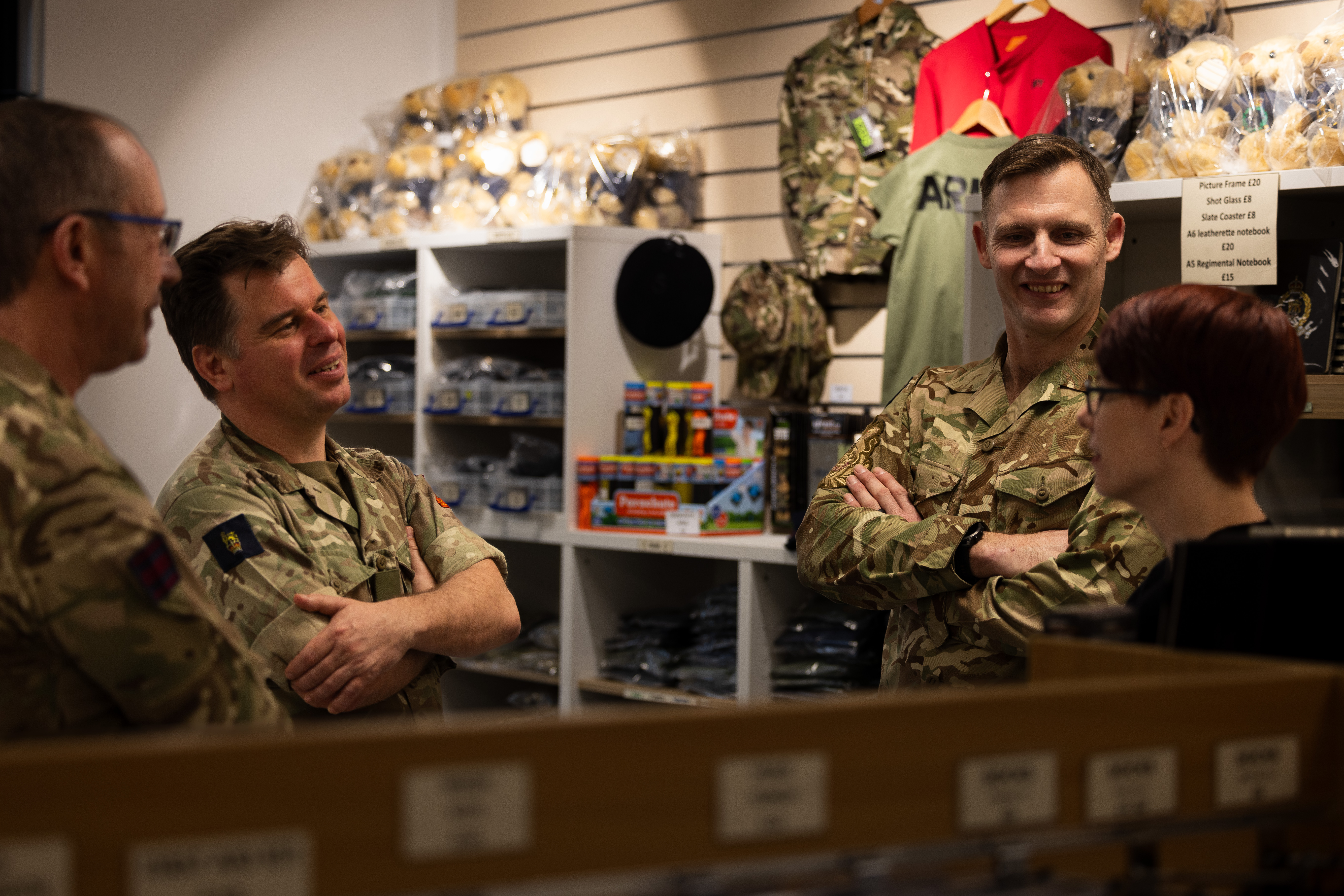 Army personnel are pictured conversing inside of a gift shop.