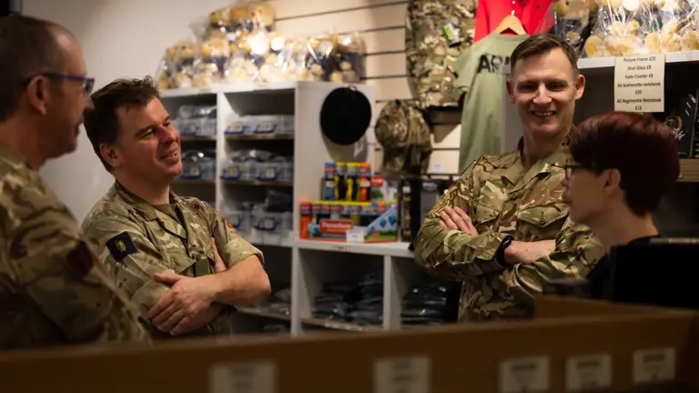 Army personnel are pictured conversing inside of a gift shop.