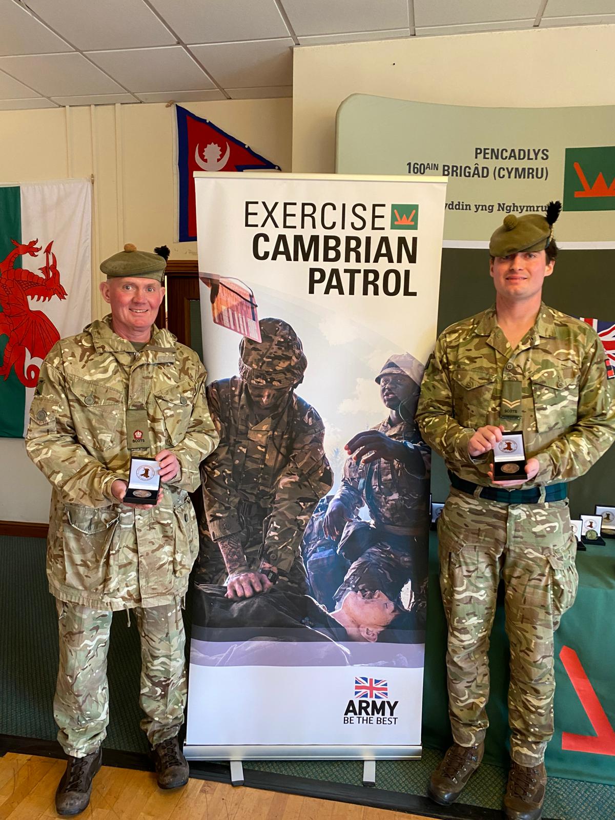 Two men in uniform are pictured with their Cambrian Patrol medals.