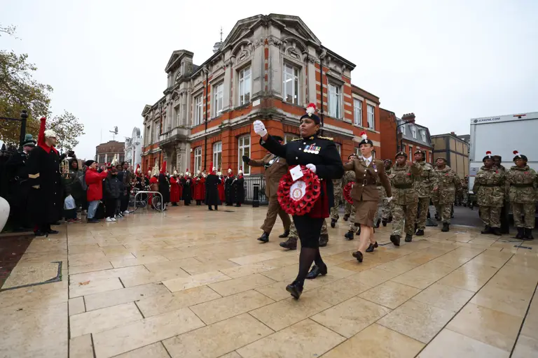 Members of the Army Cadet Force march while wearing camouflage uniforms.