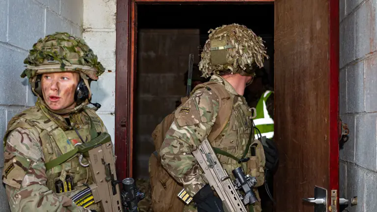 Two personnel in uniform are pictured within a doorway.