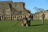 A number of soldiers are gathered around the perimeter of Richmond castle, a British Army Padre stands in the centre. 