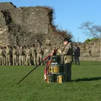 A number of soldiers are gathered around the perimeter of Richmond castle, a British Army Padre stands in the centre.