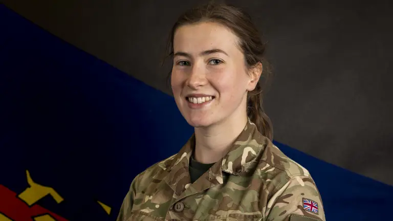 Female soldier stood posing for a portrait wearing her camouflage uniform.