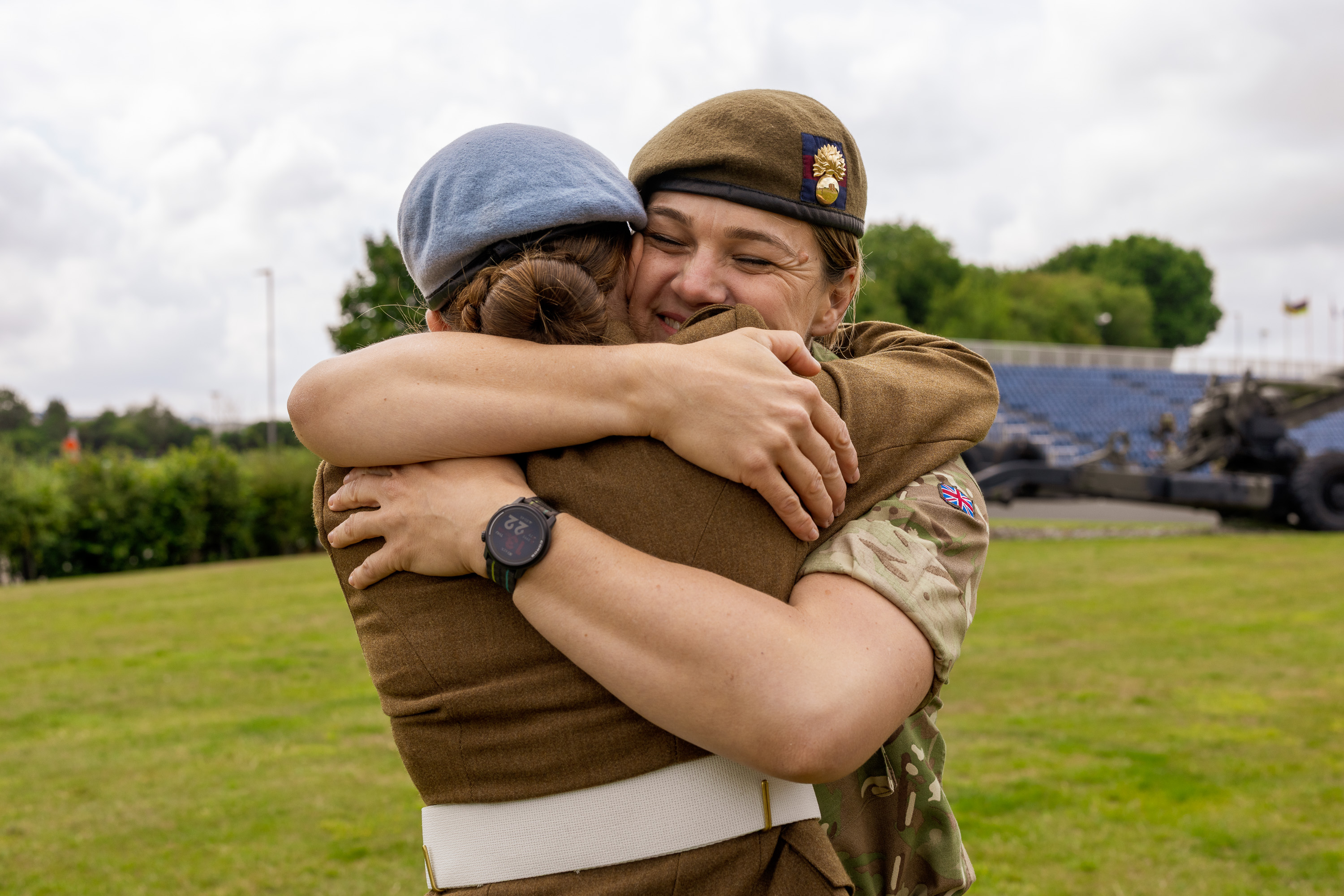 Chloe is photographed in her brown uniform and blue Army Air Corps beret stood next to her mum Sherene who is dressed in her camouflage uniform. They are both smiling and have their arms around each embracing in a hug.