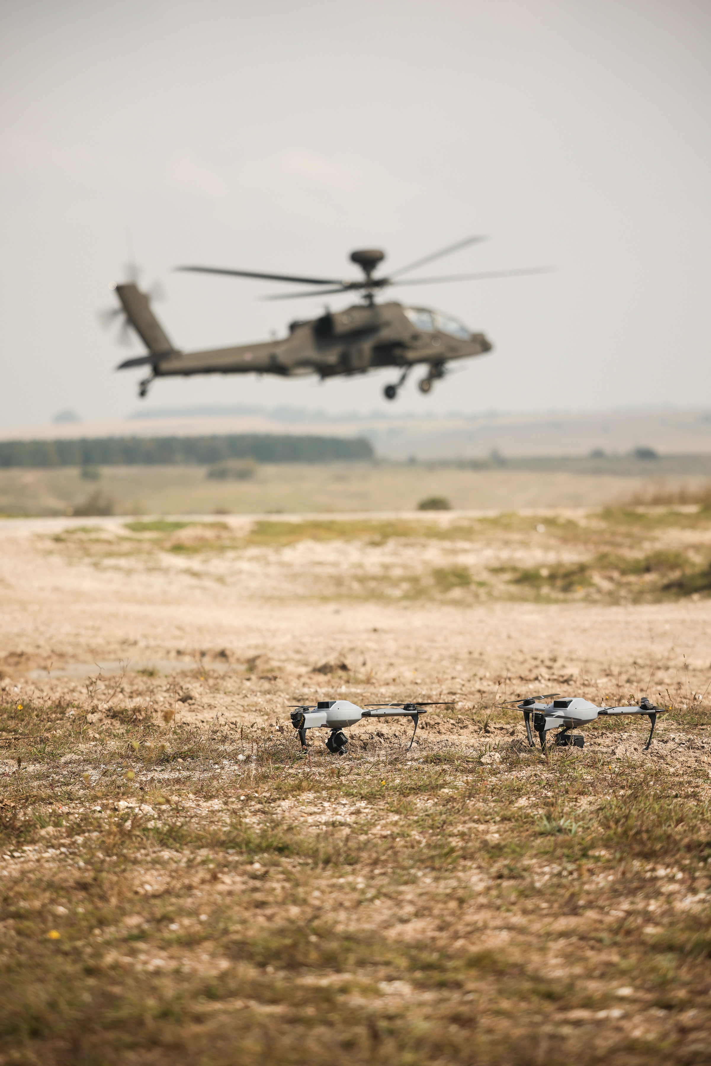 A helicopter is pictured in the background, drones are pictured closer to the camera. 