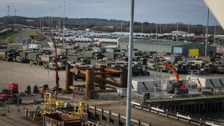 A port is pictured with many Army vehicles present.