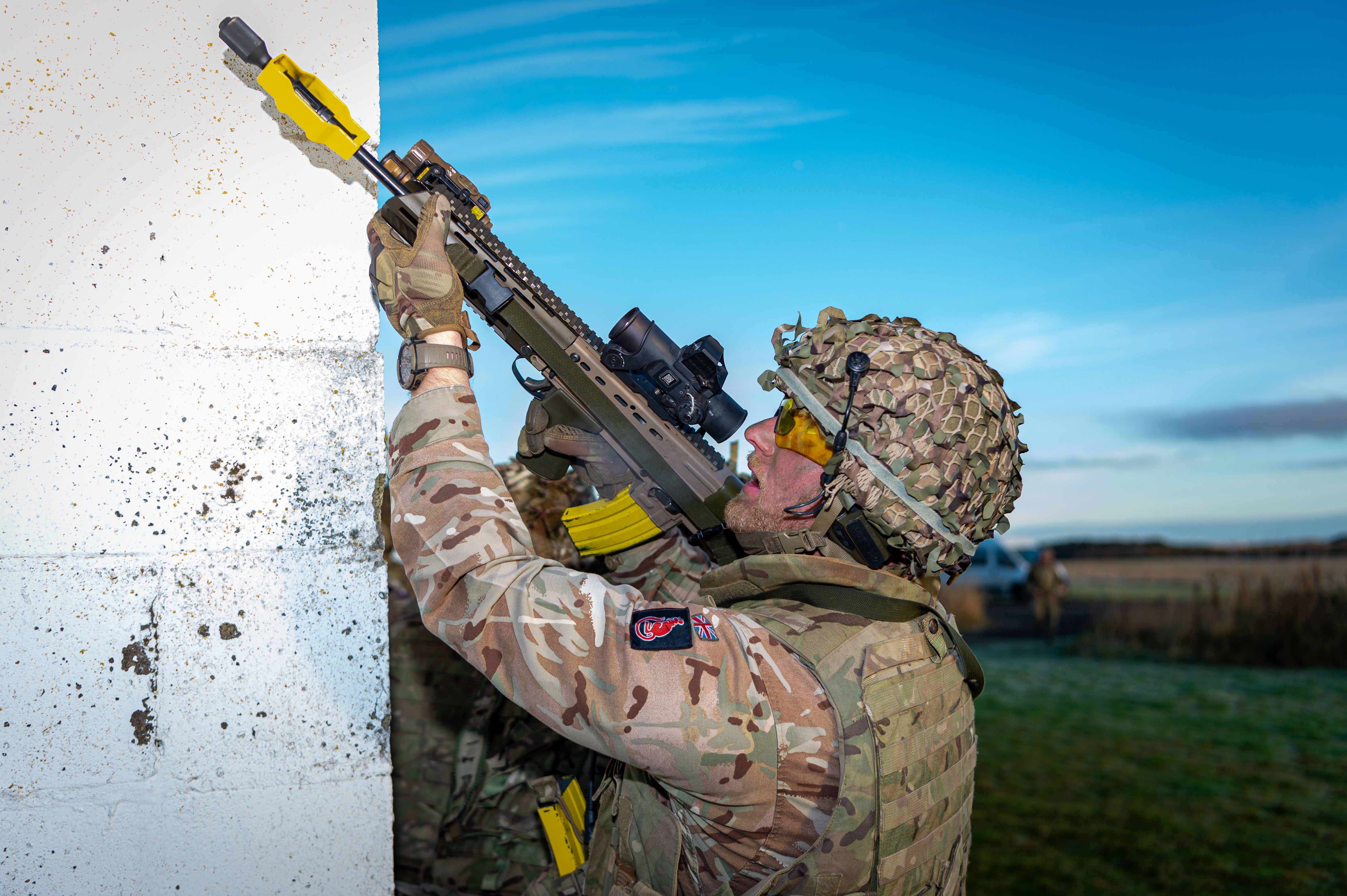 A man in uniform is pictured aiming a weapon during an exercise. 