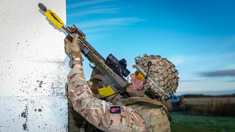 A man in uniform is pictured aiming a weapon during an exercise.