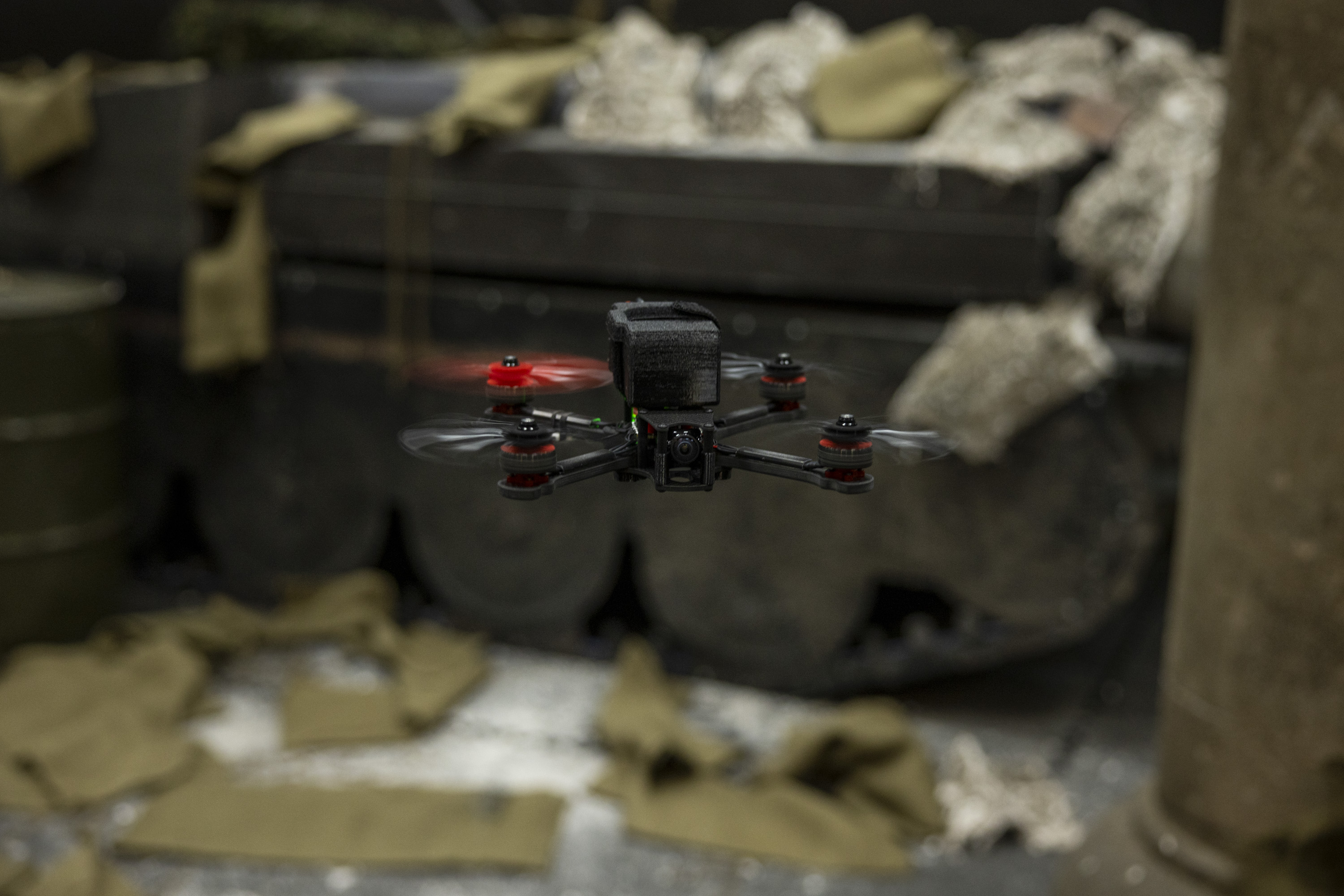 A close up of a black drone, one of the propellers is red. 