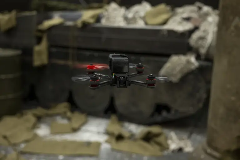 A close up of a black drone, one of the propellers is red.