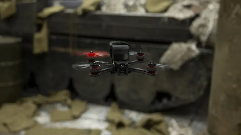 A close up of a black drone, one of the propellers is red.