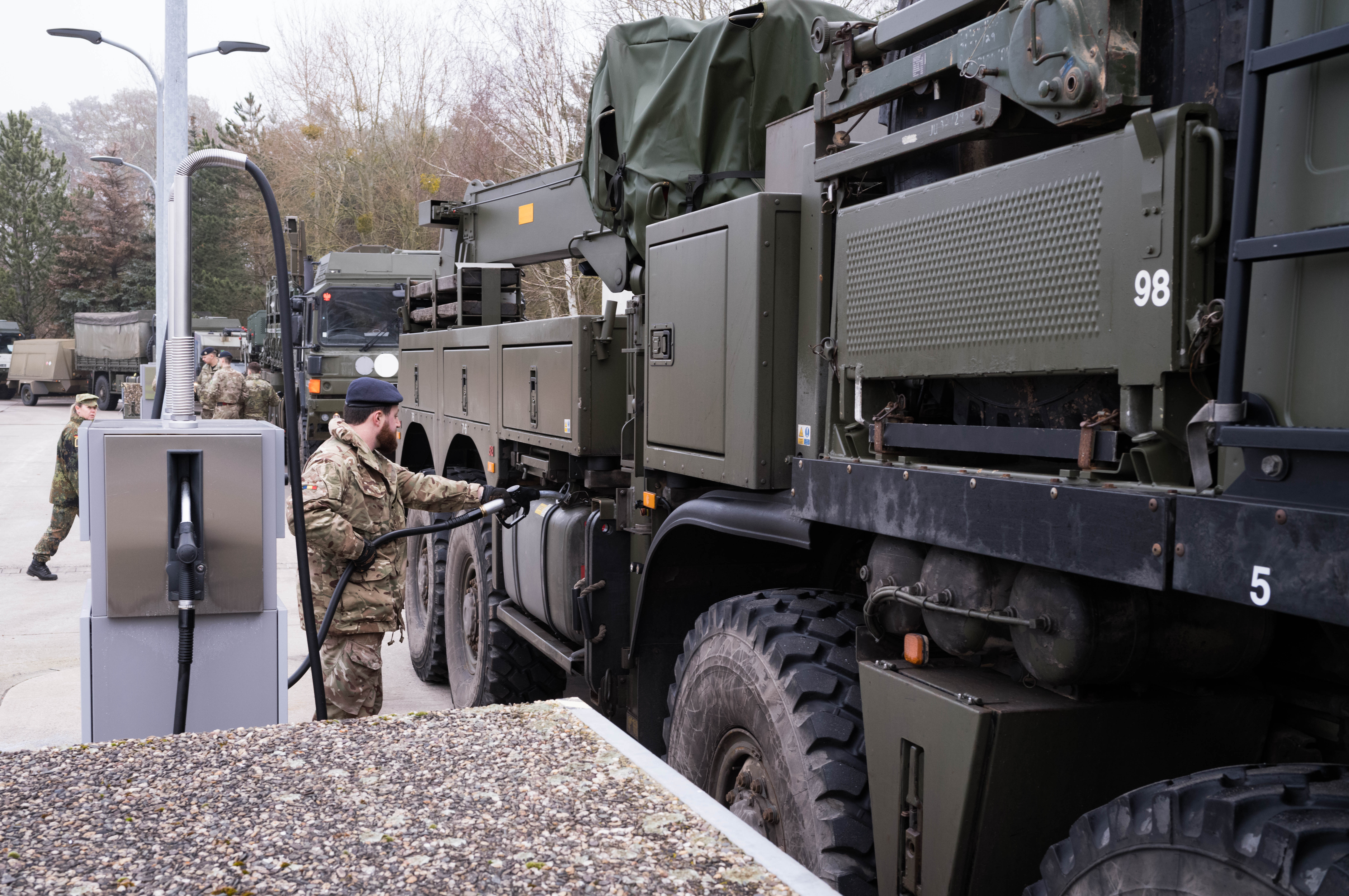 A British soldier in uniform is seen refuelling their large military vehicles on a German military base.