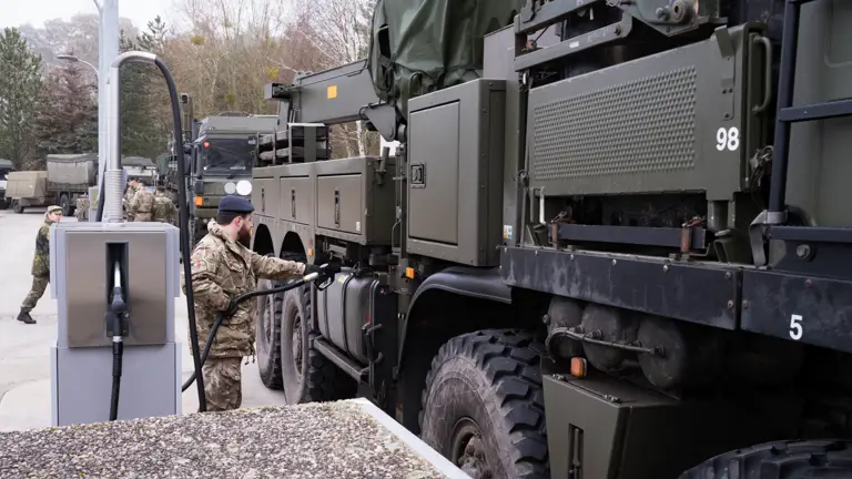 A British soldier in uniform is seen refuelling their large military vehicles on a German military base.