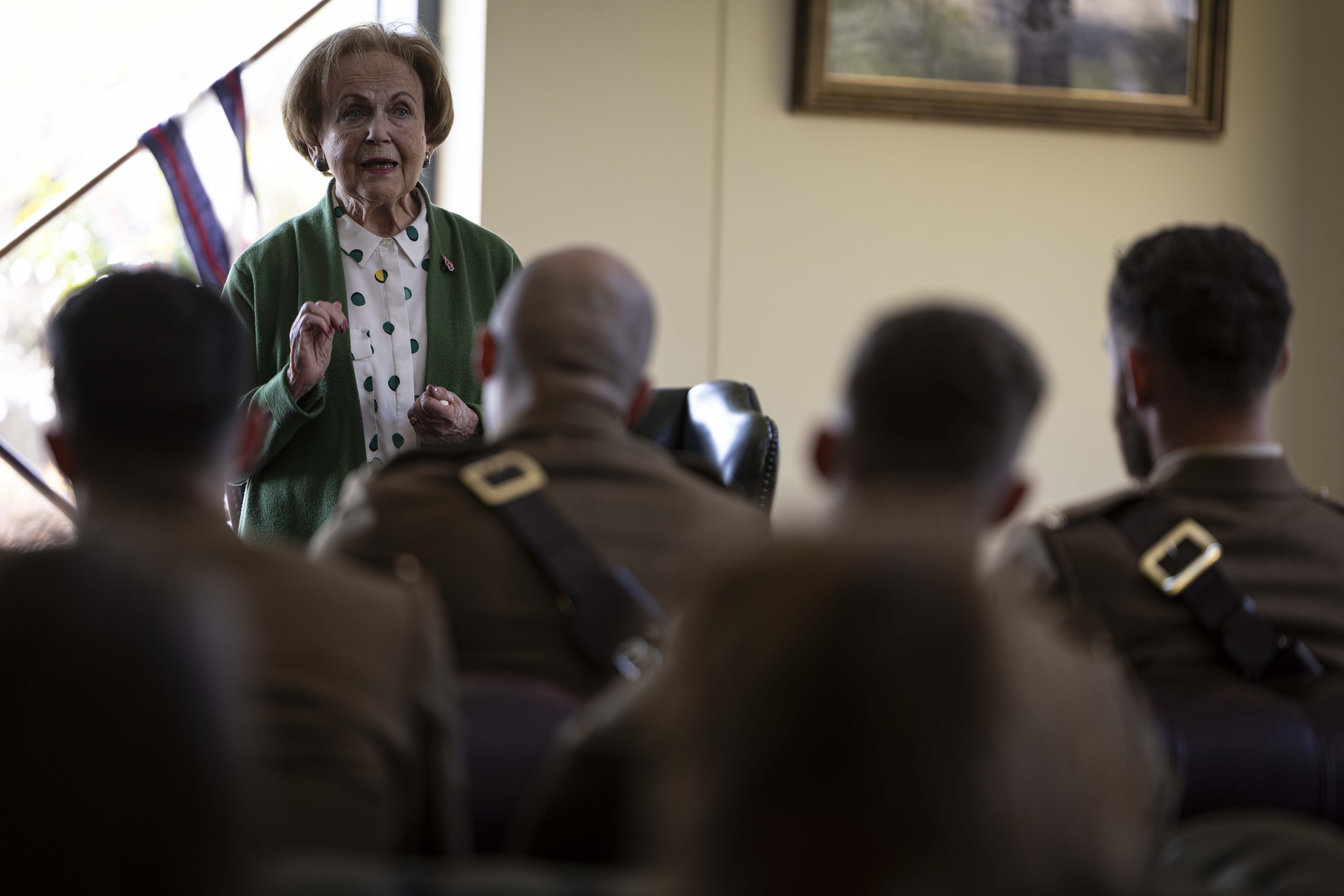 Mala Tribich MBE is stood in a room with a military audience to gives a survivor talk after the ceremony.