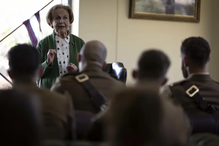 Mala Tribich MBE is stood in a room with a military audience to gives a survivor talk after the ceremony.