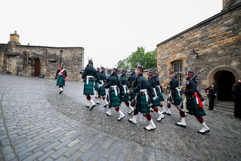 A group of soldiers in Scottish ceremonial attire are pictured walking through Edinburgh.