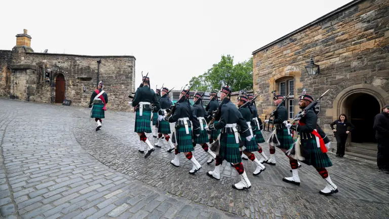A group of soldiers in Scottish ceremonial attire are pictured walking through Edinburgh.