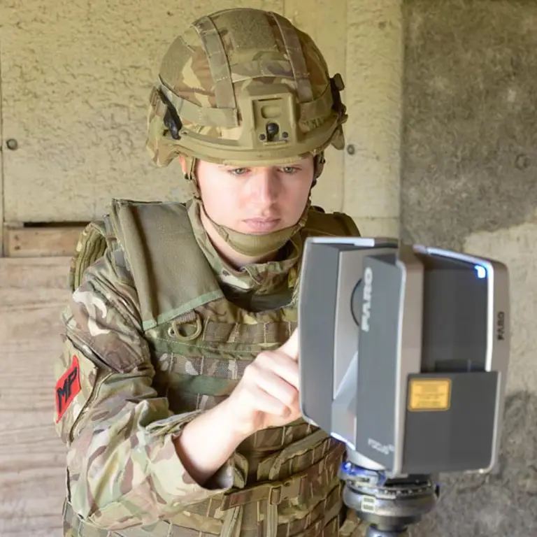 Military Police evidential imagery specialist using a laser scanner to scan a crime scene.