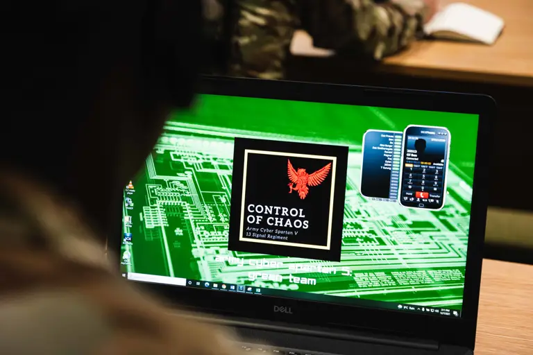 Close-up of a laptop screen displaying a digital emblem with a red eagle.