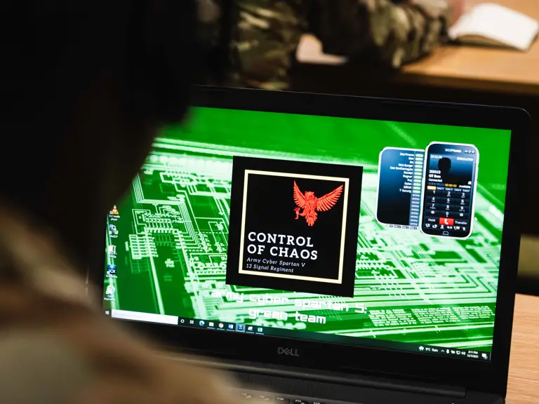 Close-up of a laptop screen displaying a digital emblem with a red eagle.