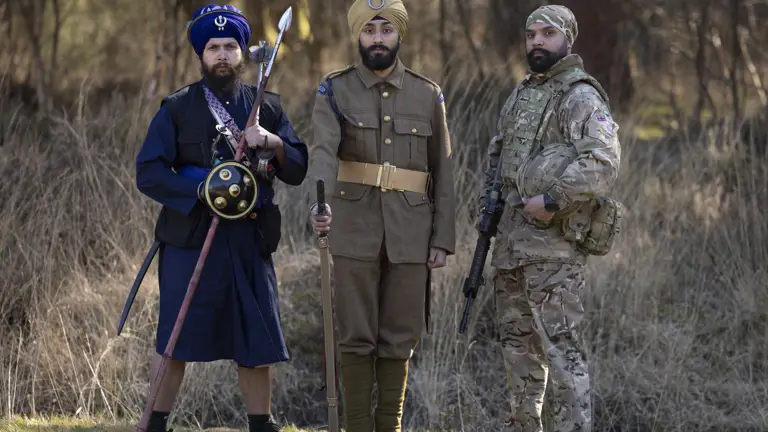 Three Sikh soldiers are pictured in different uniforms, on the left is a man in a traditional blue uniform, the man in the middle is wearing a brown World War One uniform and the man on the right is wearing the Current British Army uniform.