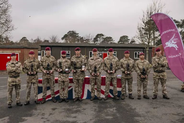Group photograph of the winning team of 216 (Para) Signals Squadron after being awarded their trophy’s after winning the 40 mile endurance march, they are dressed in their camouflage uniform and berets.