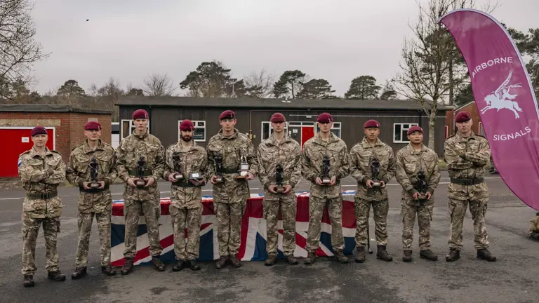 Group photograph of the winning team of 216 (Para) Signals Squadron after being awarded their trophy’s after winning the 40 mile endurance march, they are dressed in their camouflage uniform and berets.