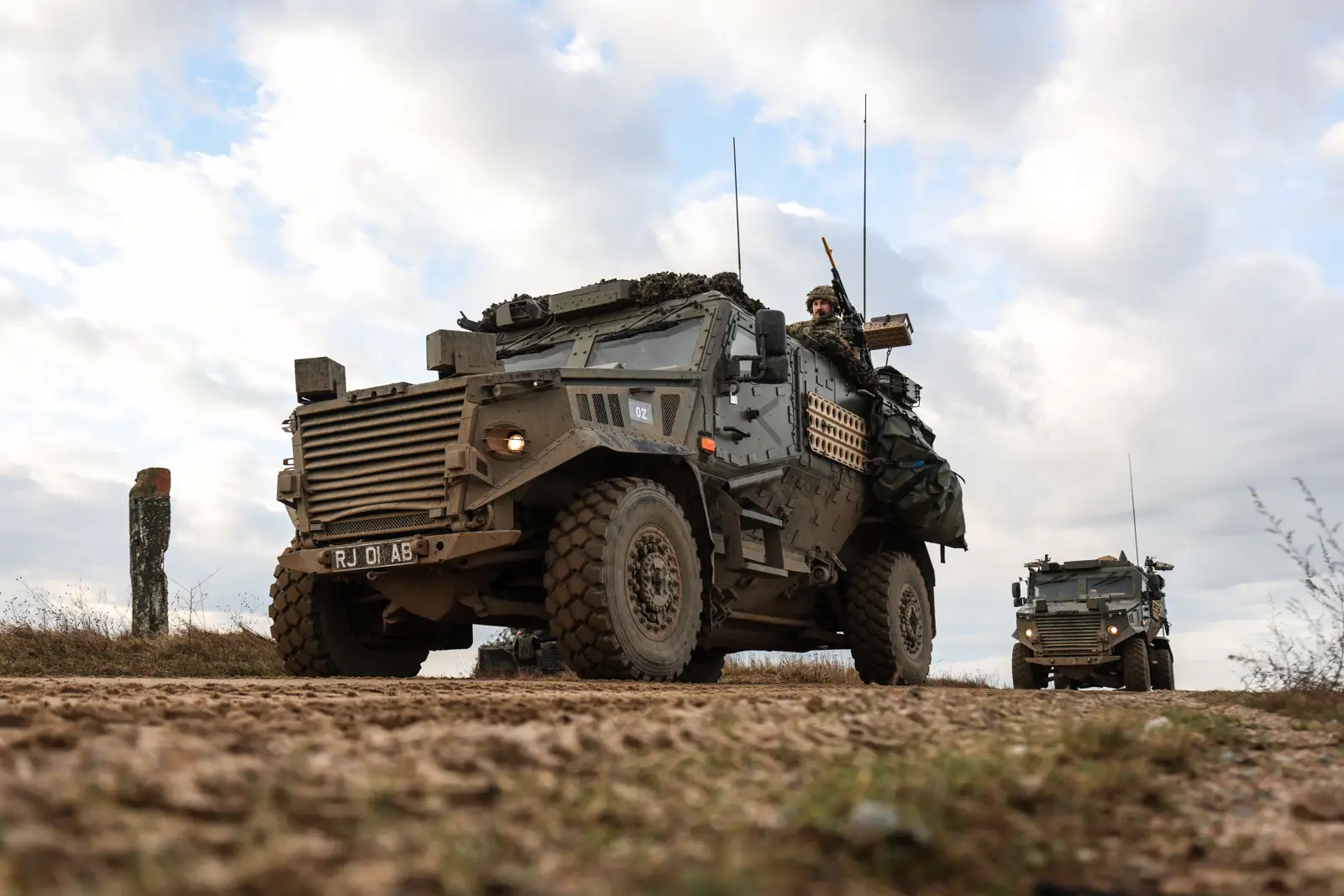 Two Foxhound vehicles photographed on exercise. The vehicles can be seen manned by soldiers.