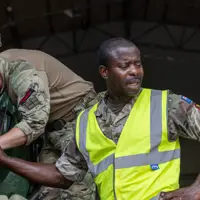 Two soldiers in uniform are pictured working with machinery