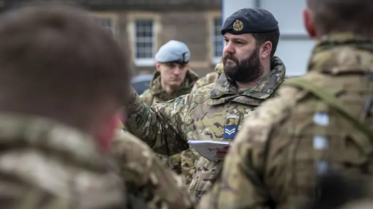 Soldiers in camouflage uniform are seen getting briefed before the ride in a Chinook.