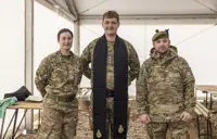 A British Army padre is pictured in between a man and a woman in uniform.