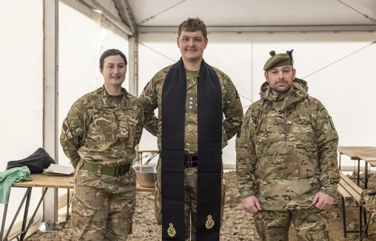 A British Army padre is pictured in between a man and a woman in uniform.