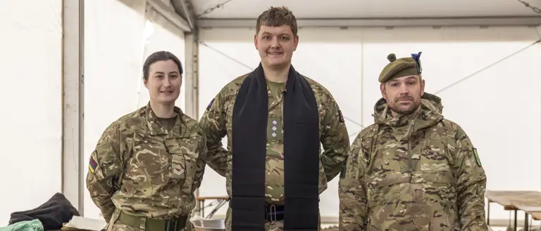 A British Army padre is pictured in between a man and a woman in uniform.