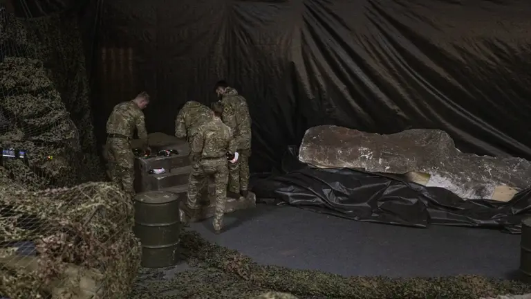 Four men in uniform are pictured setting up drones.