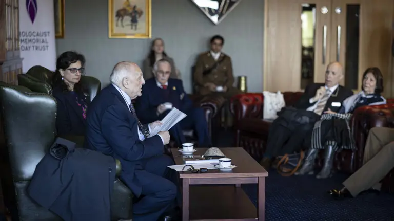 Dr Alfred Garwood is sat in a room with a military audience to gives a survivor talk after the ceremony.