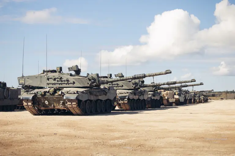 Many green tanks are lined up side by side.