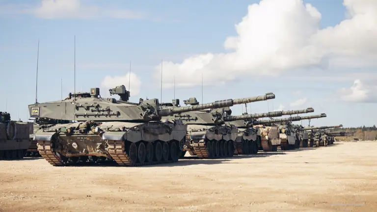 Many green tanks are lined up side by side.