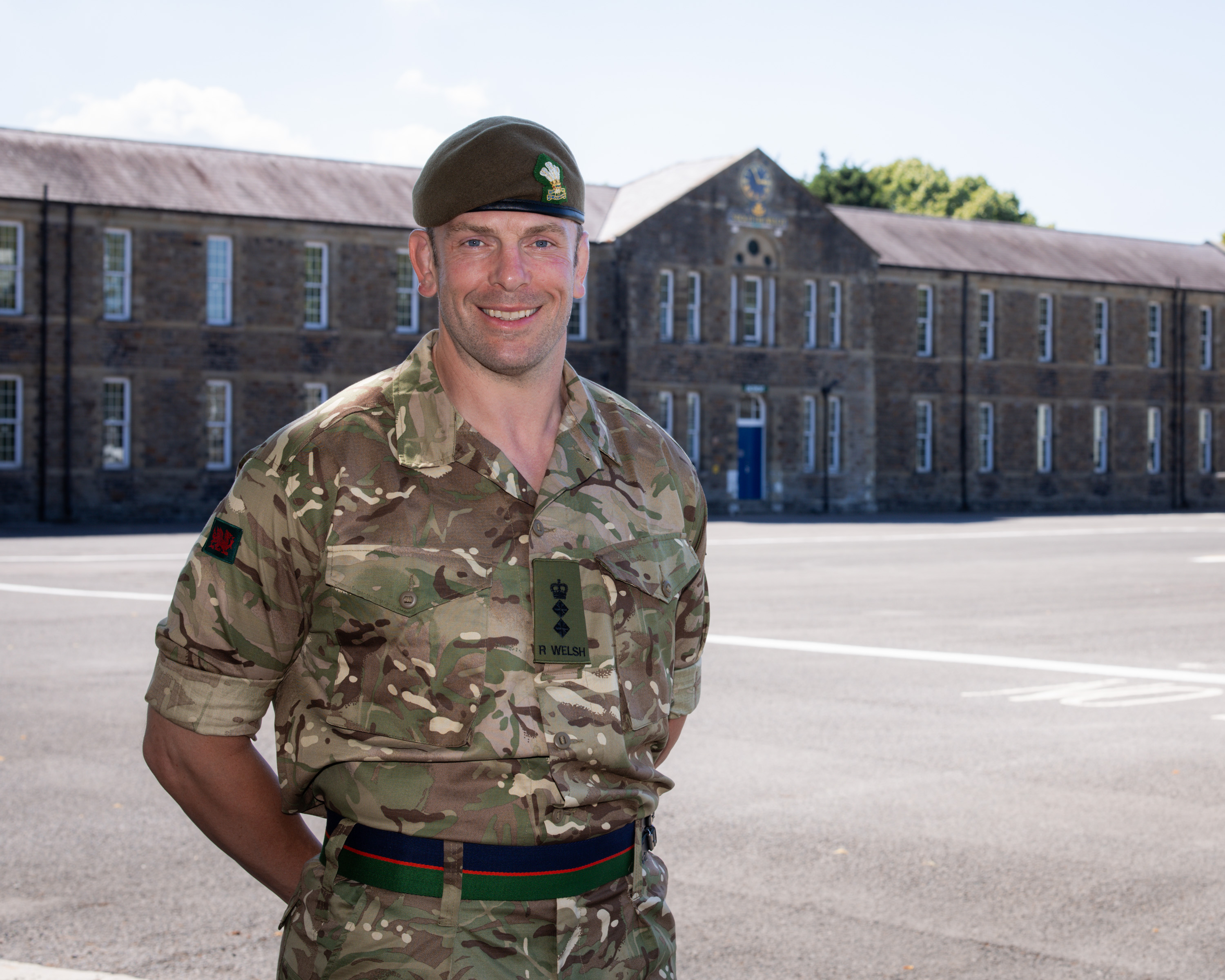 Alun Wyn Jones stands with his hands behind his back. He is wearing a camouflage uniform.