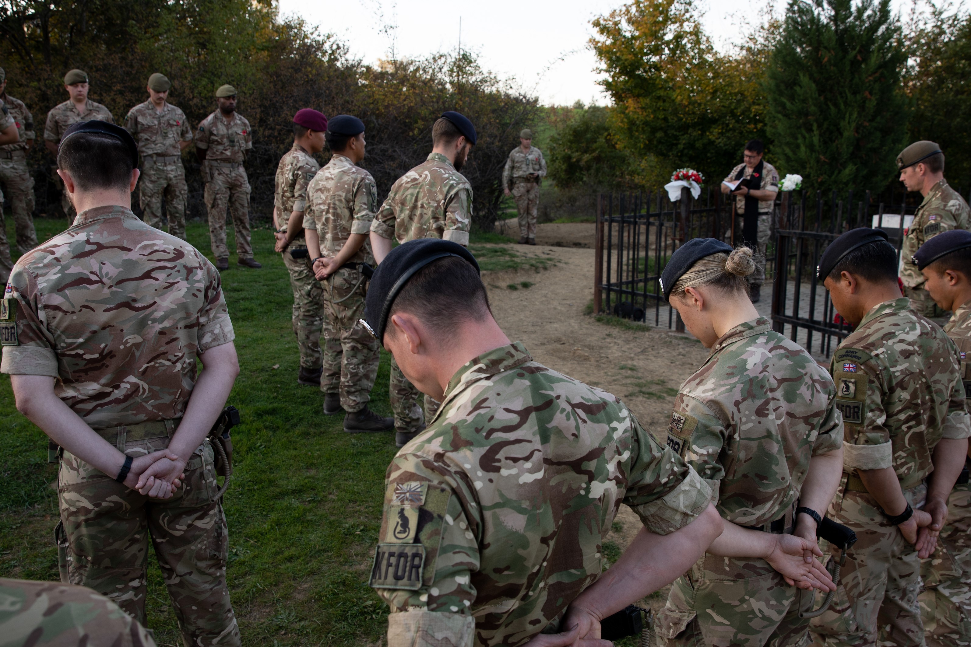 Soldiers bow their heads in a ceremony of remembrance.