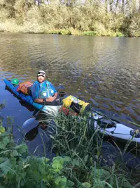 A man is pictured in canoe on a river. 