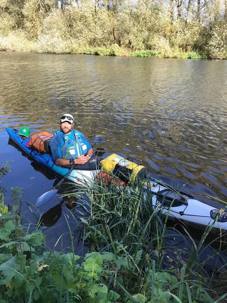 A man is pictured in canoe on a river. 