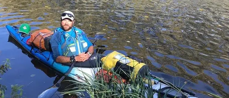 A man is pictured in canoe on a river.