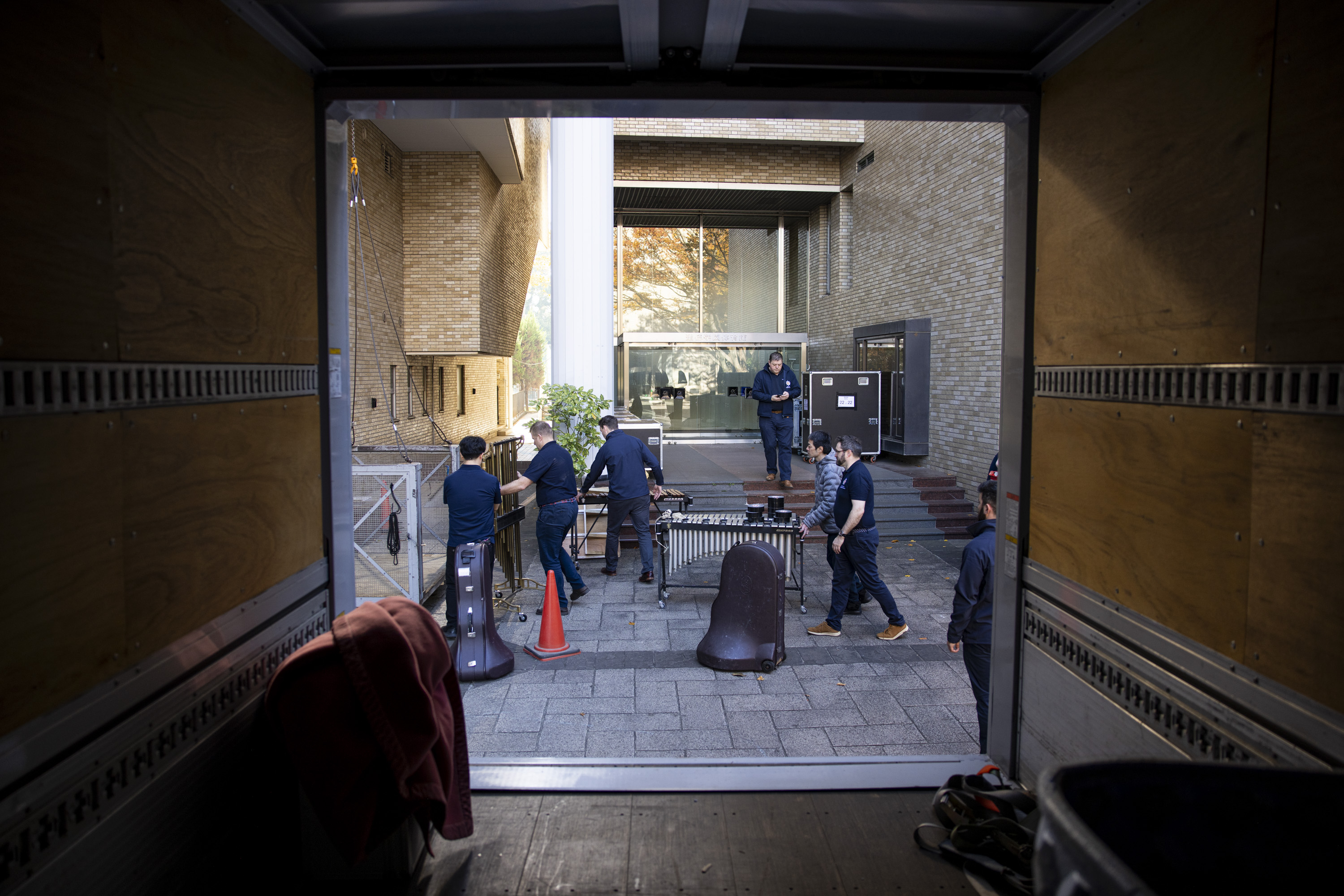 Soldiers wearing their tour uniform unload their instruments. 