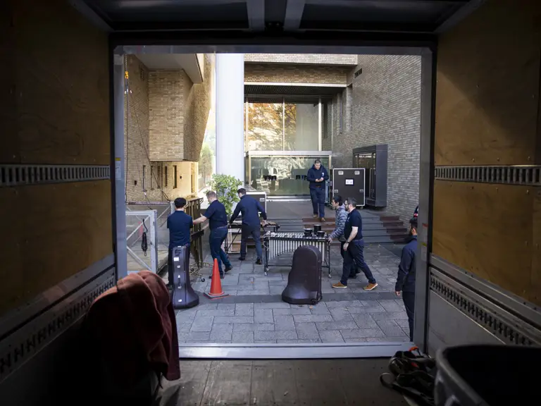 Soldiers wearing their tour uniform unload their instruments.