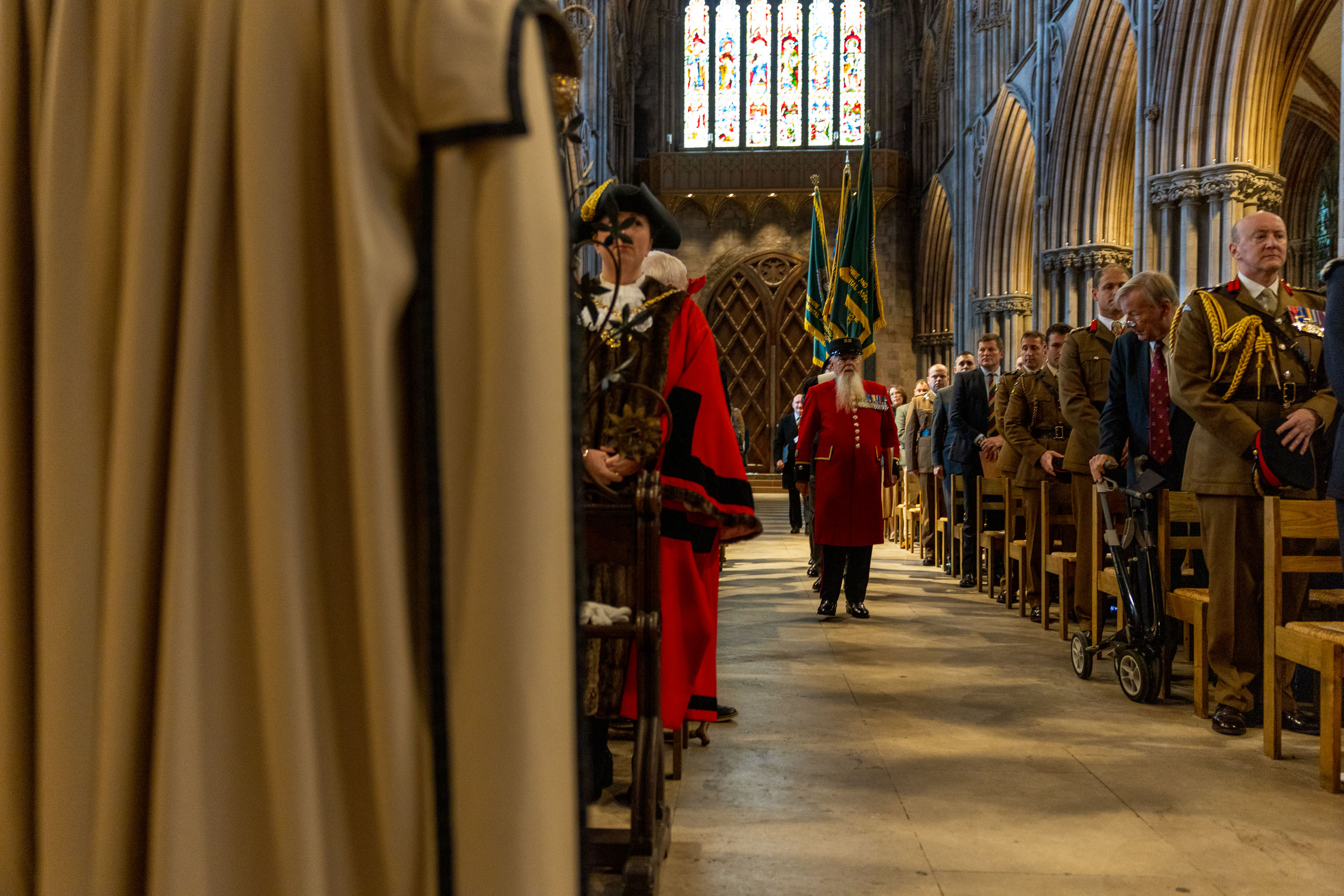 Inside the cathedral soldiers and guests line the chairs each side of the aisle. The colours are being marched down the aisle in uniform.