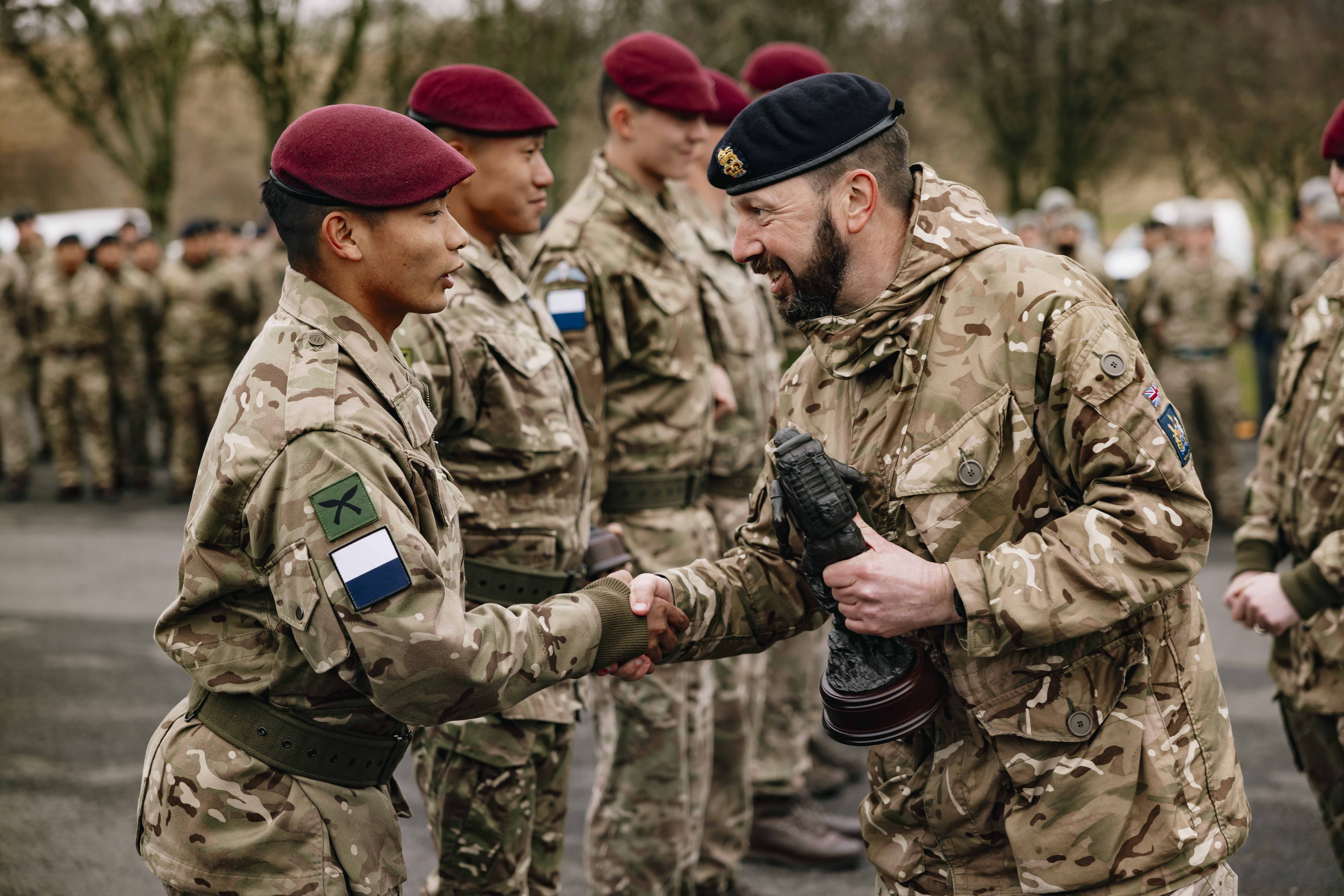 A signaller from the winning team of 216 (Para) Signals Squadron is awarded a trophy on the parade square.